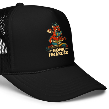 Perched atop his treasure trove of books, this red nerdy dragon is ready to devour epic adventures, magic tales, and fantasy worlds. The words 'BOOK HOARDER' are placed at the bottom of the design.