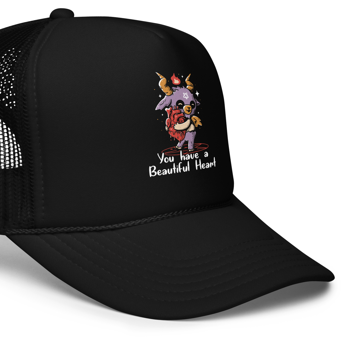 The design features a cute, cartoonish, anthropomorphic goat with big horns and a flame above its head, standing on a red pentagram. The goat has a star on its forehead and is hugging a large, anatomically correct human heart. The text below reads, 'You have a Beautiful Heart'. The image combines elements of occult symbolism with a playful, endearing aesthetic.