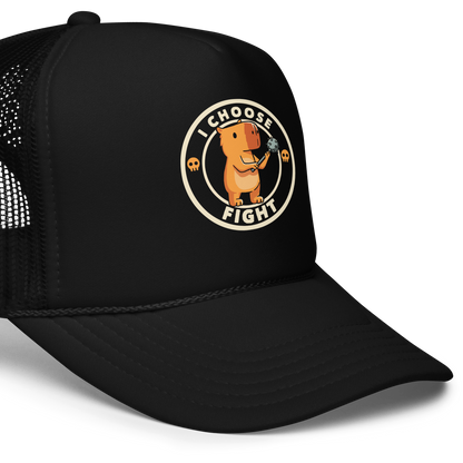 A cute, cartoon-style capybara stands upright holding a spiked mace with both hands. The image is framed by a circular border, inside of which the words 'I Choose Fight' are written in bold, playful letters. The design is accented with two small skull icons on either side, evoking a humorous take on combat readiness.