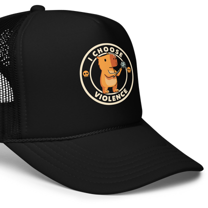 A cute, cartoonish burnt yellow capybara stands holding a spiked mace with a determined expression. Surrounding it is a circular design with the text 'I CHOOSE VIOLENCE' and two small skulls on either side, giving it a humorous yet ironic tone.
