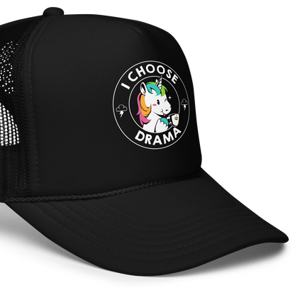 A cartoon unicorn with rainbow-colored mane holds a cup of tea and a heart, encircled by the words 'I Choose Drama'. Two small clouds with lightning bolts flank the unicorn, adding a playful yet slightly edgy vibe. The design is bold and whimsical with a pop-art influence.