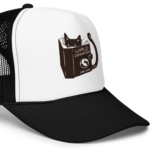 The design features a black silhouette of a cat peeking from behind an oversized book. The book's cover reads 'World Domination for Cats,' and includes a simple drawing of a globe. The cat's eyes are wide open, suggesting either surprise or intense focus on its 'world domination' plans.