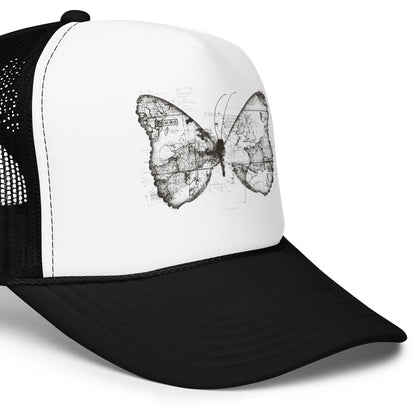 The image features a black and white butterfly where the wings are created using ancient world map designs. The maps overlay in intricate detail, blending geographical elements with the organic shape of the butterfly. Surrounding the butterfly are faint outlines of text and additional geographic features, creating a vintage and exploratory vibe.