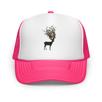 The image depicts a dark, silhouetted deer standing on a neutral background. Instead of branches, its antlers transform into a swirling cloud of vibrant, colorful butterflies that extend upwards and outward. The mix of organic and ethereal elements creates a captivating and whimsical visual contrast.