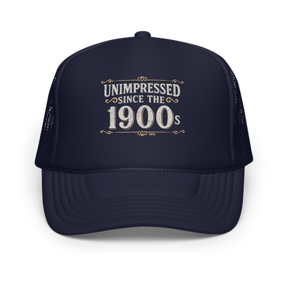 Vintage-style graphic with the phrase “Unimpressed Since the 1900s” in bold distressed lettering, decorated with ornate flourishes and a retro color palette.