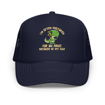 Cute cartoon dinosaur standing with a funny expression, accompanied by the humorous phrase “I’m Often Mistaken for an Adult Because of My Age” in bold distressed lettering.