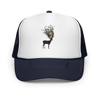 The image depicts a dark, silhouetted deer standing on a neutral background. Instead of branches, its antlers transform into a swirling cloud of vibrant, colorful butterflies that extend upwards and outward. The mix of organic and ethereal elements creates a captivating and whimsical visual contrast.