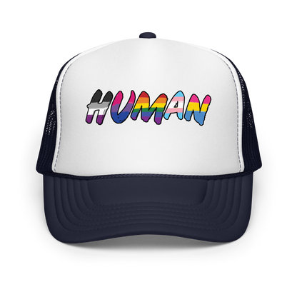 The image displays the word 'HUMAN' in bold, capitalized letters filled with colorful pride flag patterns. The colors within the letters represent different LGBTQ+ pride flags, symbolizing inclusivity and diversity. The background is solid black, which makes the colorful patterns stand out more vibrantly.