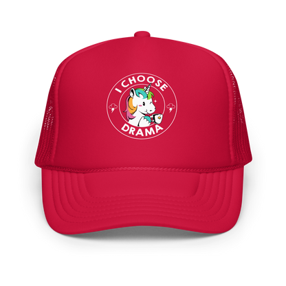 A cartoon unicorn with rainbow-colored mane holds a cup of tea and a heart, encircled by the words 'I Choose Drama'. Two small clouds with lightning bolts flank the unicorn, adding a playful yet slightly edgy vibe. The design is bold and whimsical with a pop-art influence.