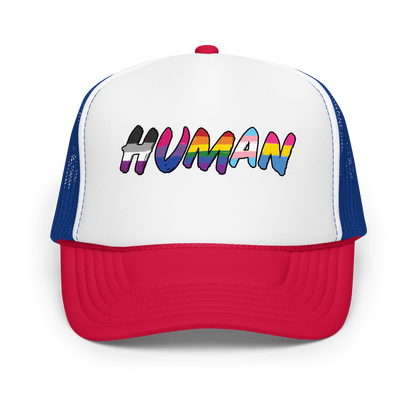 The image displays the word 'HUMAN' in bold, capitalized letters filled with colorful pride flag patterns. The colors within the letters represent different LGBTQ+ pride flags, symbolizing inclusivity and diversity. The background is solid black, which makes the colorful patterns stand out more vibrantly.