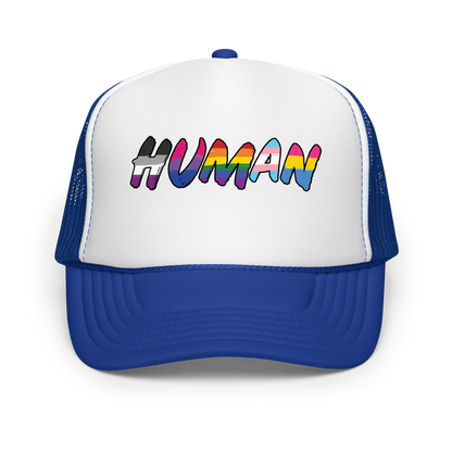 The image displays the word 'HUMAN' in bold, capitalized letters filled with colorful pride flag patterns. The colors within the letters represent different LGBTQ+ pride flags, symbolizing inclusivity and diversity. The background is solid black, which makes the colorful patterns stand out more vibrantly.
