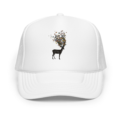 The image depicts a dark, silhouetted deer standing on a neutral background. Instead of branches, its antlers transform into a swirling cloud of vibrant, colorful butterflies that extend upwards and outward. The mix of organic and ethereal elements creates a captivating and whimsical visual contrast.