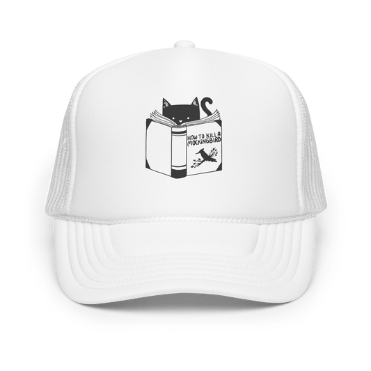 A black and white illustration features a cat peeking over an open book titled 'How to Kill a Mockingbird,' playfully altering the classic novel's title. The cat has a heart-shaped nose and simple, cute facial features. The design is whimsical and ironic, combining classic literature with a humorous twist.