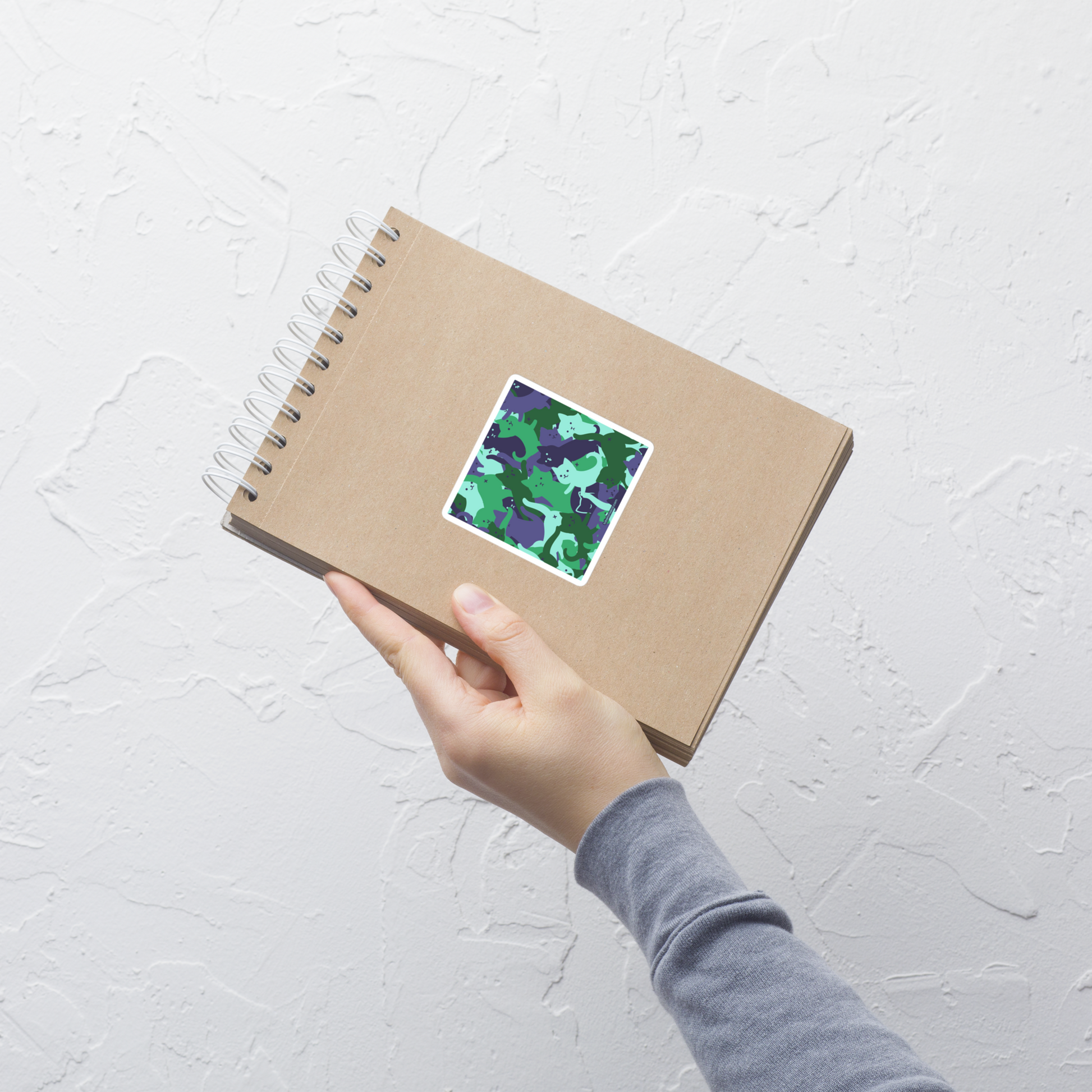 A playful pattern featuring multiple kittens in shades of green and blue, arranged to create a soft camouflage effect. This design blends cute cats with a modern pattern aesthetic, perfect for fans of fun, stylish, and whimsical art.
