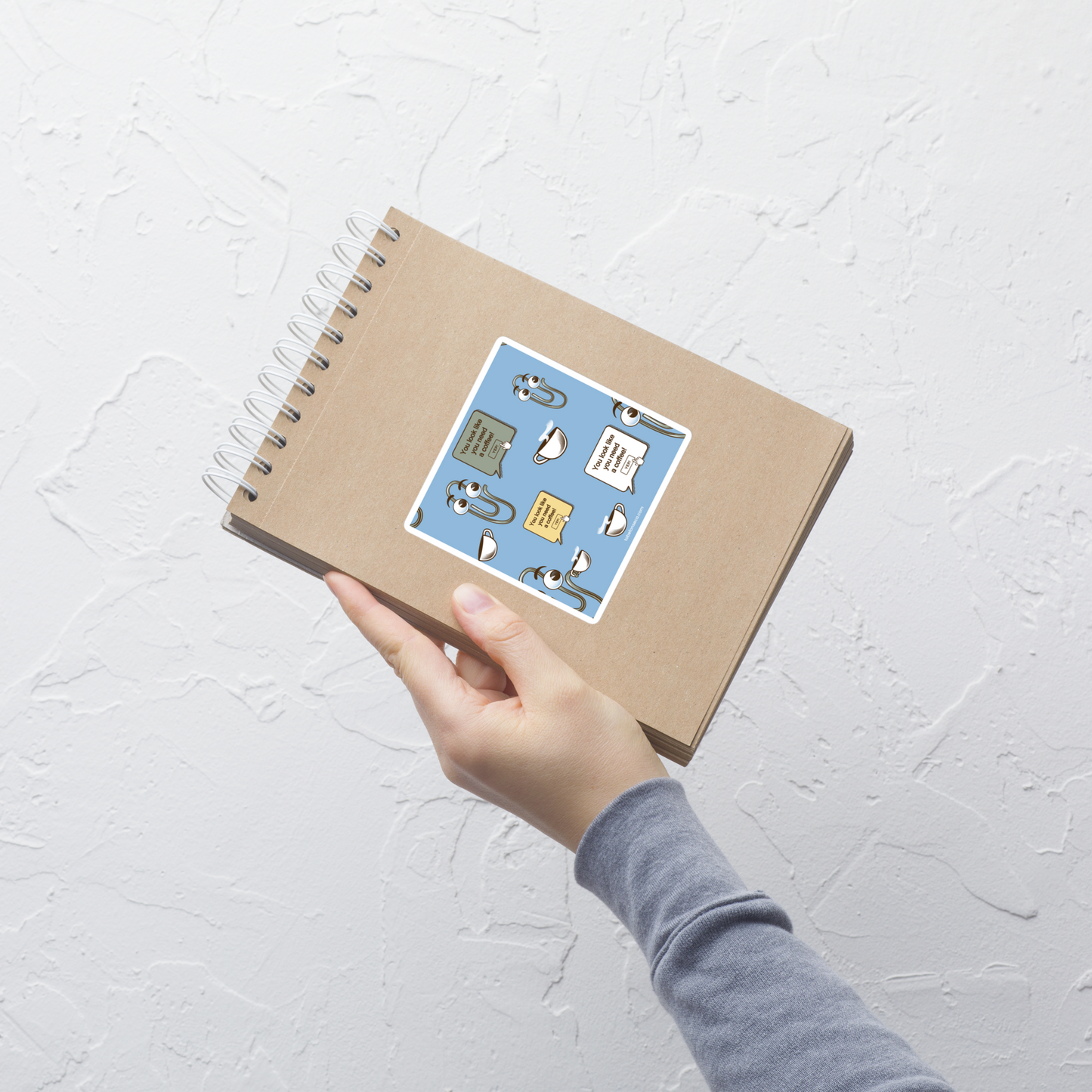 A seamless pattern featuring a cute retro-style paperclip character holding a cup of coffee, paired with the phrase “You Look Like You Need a Coffee”. A playful and relatable design inspired by classic office nostalgia, perfect for coffee lovers, work-from-home routines, and anyone who survives the day one cup at a time.