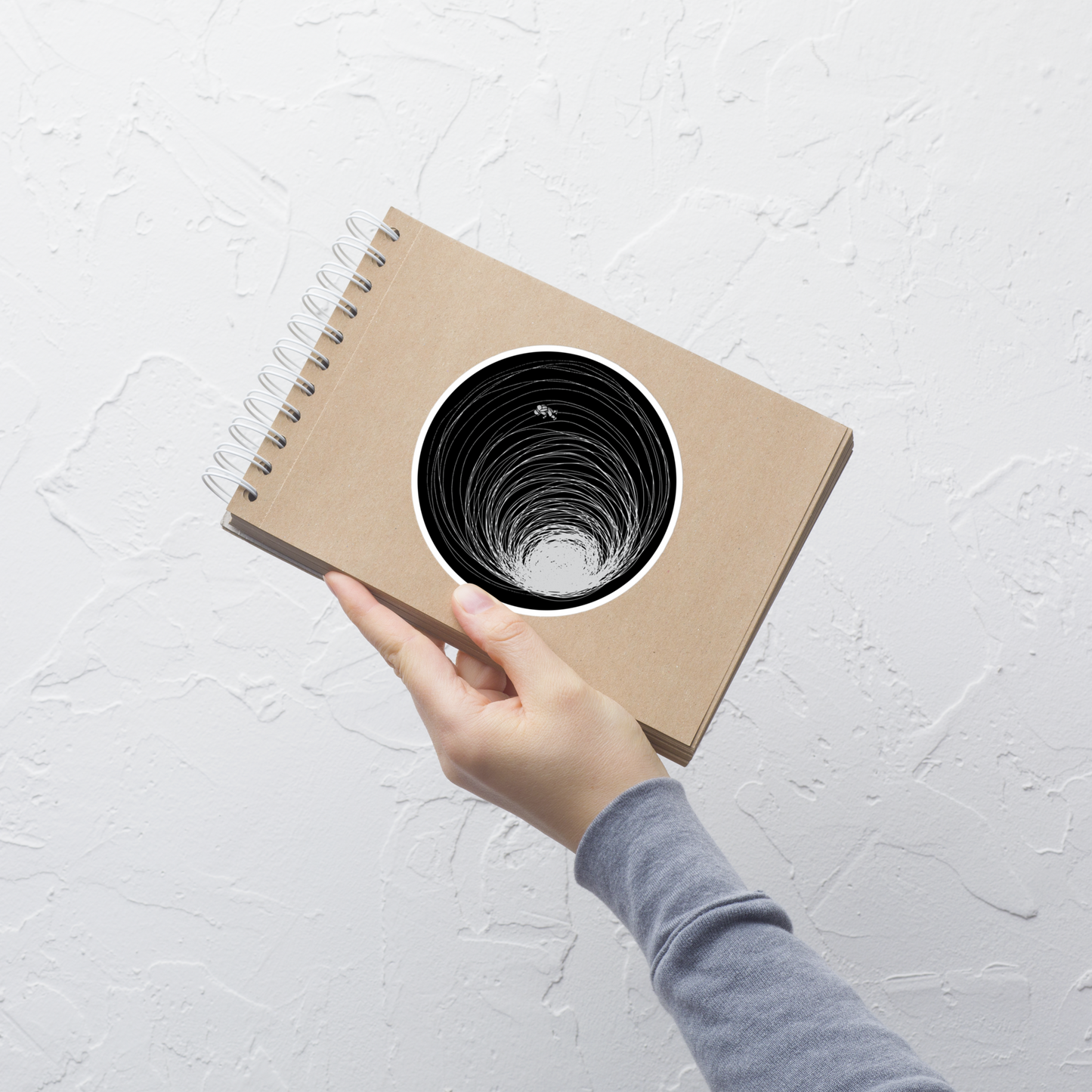 A big black hole with an astronaut floating around as if being sucked into it. A minimalist art perfect for those who love space.