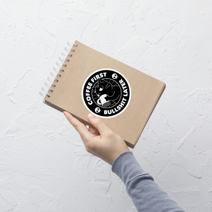 A black cat enjoys a hot cup of coffee, surrounded by the phrase “Coffee First Bullshit Later” adorned with skulls. This design combines dark humor with a touch of humor, perfect for those who face the day with equal doses of coffee and sarcasm. Made for lovers of felines, sarcasm and that extra dose of morning caffeine.