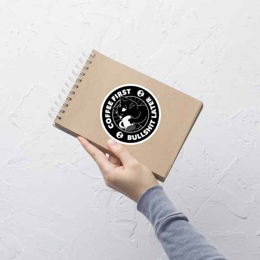 A black cat enjoys a hot cup of coffee, surrounded by the phrase “Coffee First Bullshit Later” adorned with skulls. This design combines dark humor with a touch of humor, perfect for those who face the day with equal doses of coffee and sarcasm. Made for lovers of felines, sarcasm and that extra dose of morning caffeine.