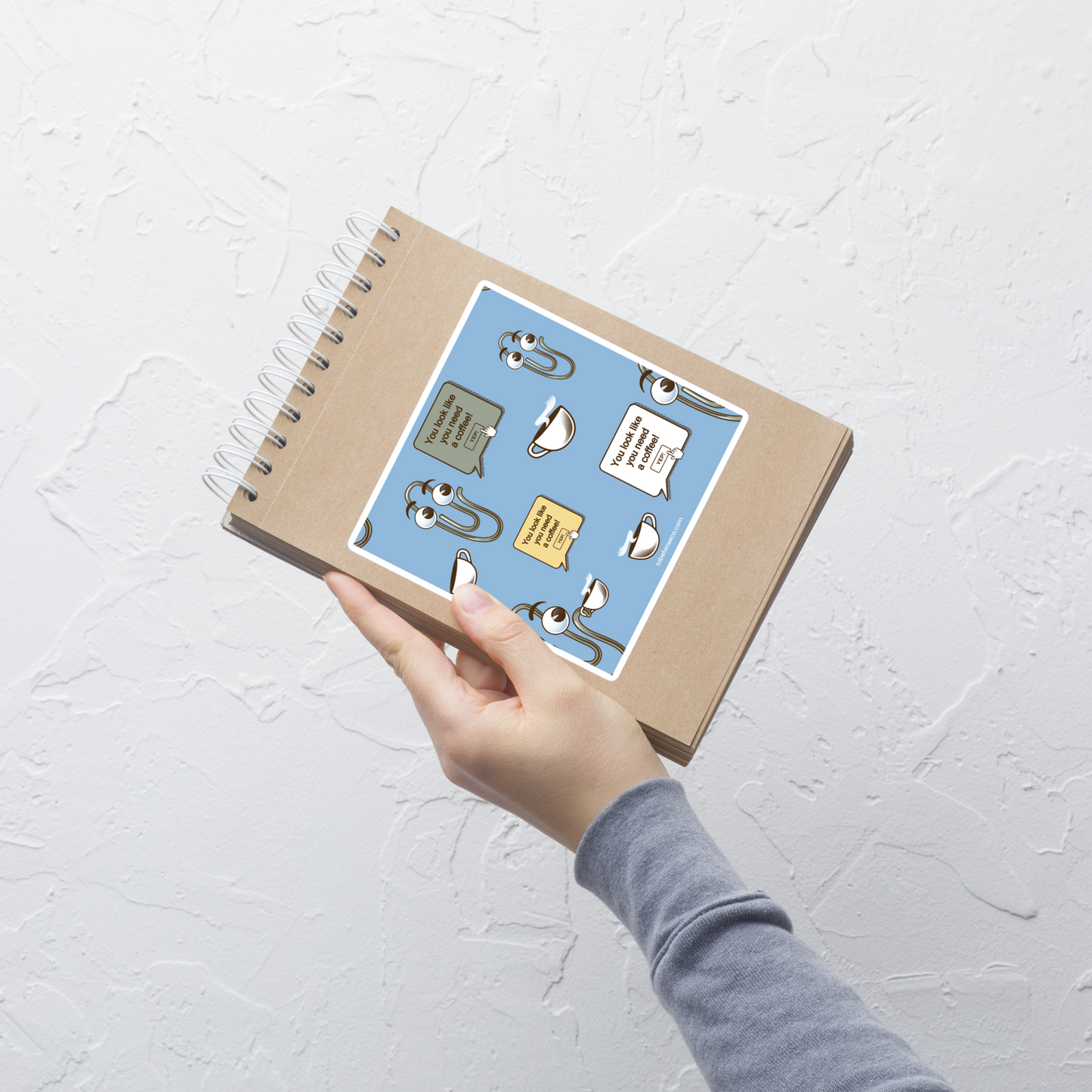 A seamless pattern featuring a cute retro-style paperclip character holding a cup of coffee, paired with the phrase “You Look Like You Need a Coffee”. A playful and relatable design inspired by classic office nostalgia, perfect for coffee lovers, work-from-home routines, and anyone who survives the day one cup at a time.