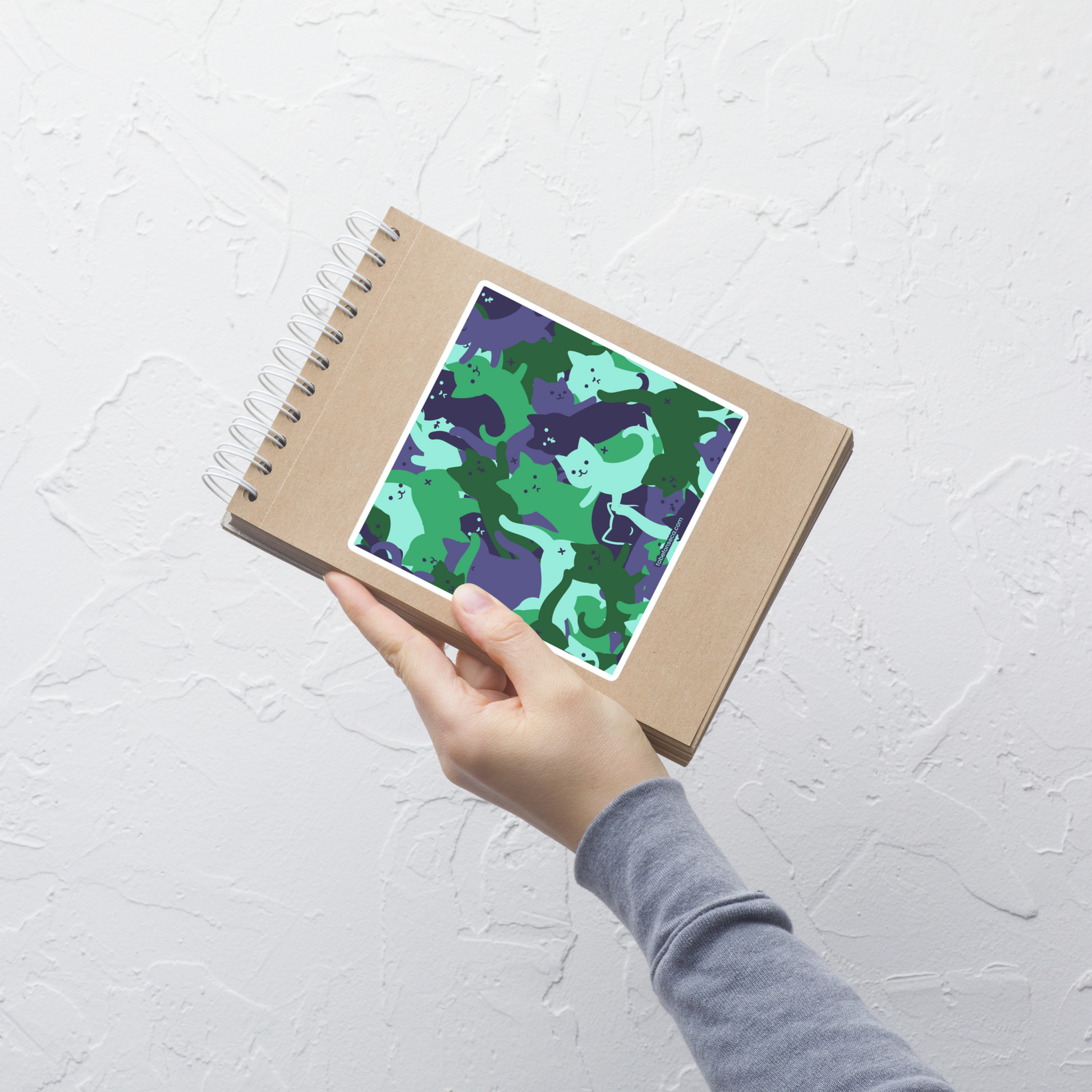 A playful pattern featuring multiple kittens in shades of green and blue, arranged to create a soft camouflage effect. This design blends cute cats with a modern pattern aesthetic, perfect for fans of fun, stylish, and whimsical art.