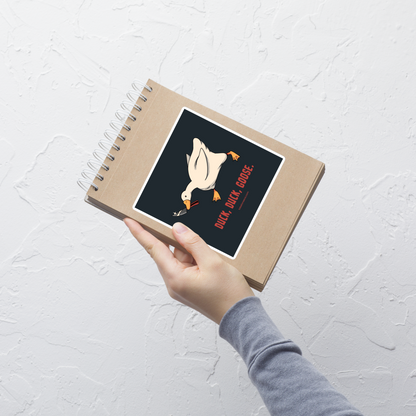 A white goose gripping a sharp knife in its beak with the phrase “Duck, Duck, Goose” below. A playful twist on the classic game, this design captures chaotic goose energy with a sharp dose of dark humor.