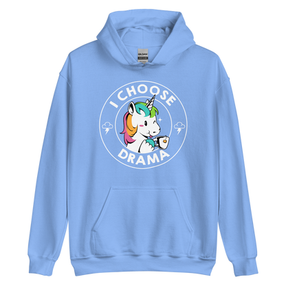 A cartoon unicorn with rainbow-colored mane holds a cup of tea and a heart, encircled by the words 'I Choose Drama'. Two small clouds with lightning bolts flank the unicorn, adding a playful yet slightly edgy vibe. The design is bold and whimsical with a pop-art influence.