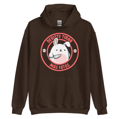 A cute white cartoon bunny with a pink belly stands holding a large kitchen knife in one paw. Surrounding the bunny is a red circular border with the words 'DEBISTE TIRAR MÁS FOTOS'. Small skull icons are on either side of the circle. The overall tone is a mix of adorable and ironic humor.