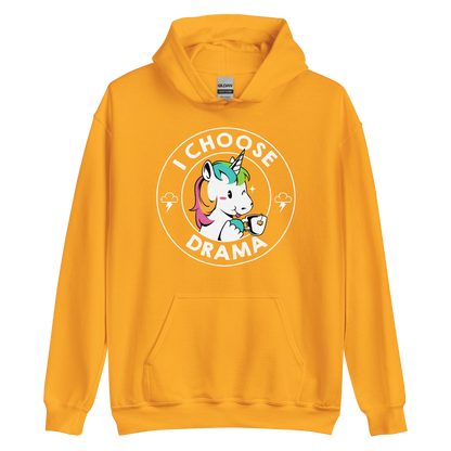 A cartoon unicorn with rainbow-colored mane holds a cup of tea and a heart, encircled by the words 'I Choose Drama'. Two small clouds with lightning bolts flank the unicorn, adding a playful yet slightly edgy vibe. The design is bold and whimsical with a pop-art influence.