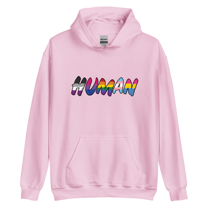 The image displays the word 'HUMAN' in bold, capitalized letters filled with colorful pride flag patterns. The colors within the letters represent different LGBTQ+ pride flags, symbolizing inclusivity and diversity. The background is solid black, which makes the colorful patterns stand out more vibrantly.