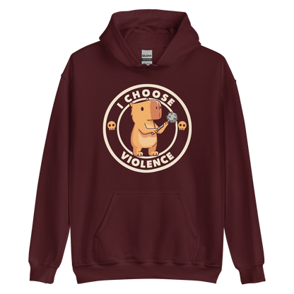A cute, cartoonish burnt yellow capybara stands holding a spiked mace with a determined expression. Surrounding it is a circular design with the text 'I CHOOSE VIOLENCE' and two small skulls on either side, giving it a humorous yet ironic tone.