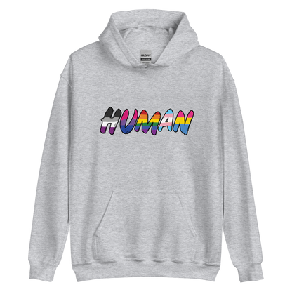 The image displays the word 'HUMAN' in bold, capitalized letters filled with colorful pride flag patterns. The colors within the letters represent different LGBTQ+ pride flags, symbolizing inclusivity and diversity. The background is solid black, which makes the colorful patterns stand out more vibrantly.