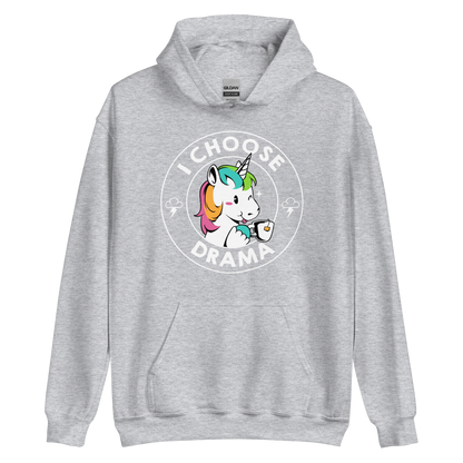 A cartoon unicorn with rainbow-colored mane holds a cup of tea and a heart, encircled by the words 'I Choose Drama'. Two small clouds with lightning bolts flank the unicorn, adding a playful yet slightly edgy vibe. The design is bold and whimsical with a pop-art influence.