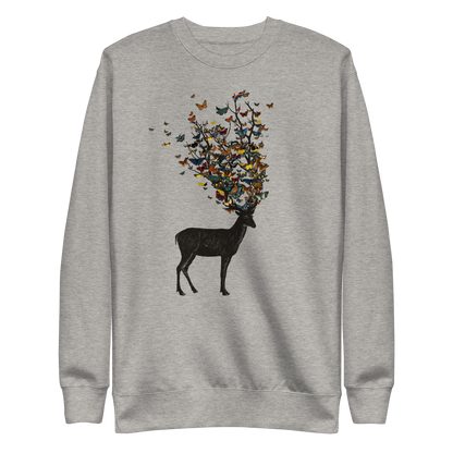 The image depicts a dark, silhouetted deer standing on a neutral background. Instead of branches, its antlers transform into a swirling cloud of vibrant, colorful butterflies that extend upwards and outward. The mix of organic and ethereal elements creates a captivating and whimsical visual contrast.