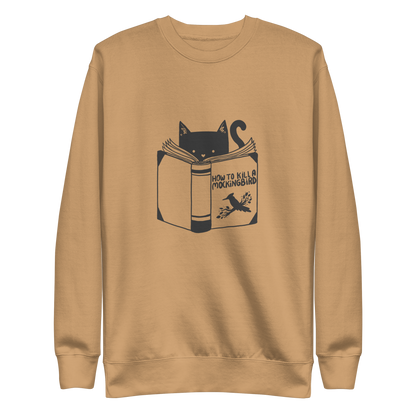 A black and white illustration features a cat peeking over an open book titled 'How to Kill a Mockingbird,' playfully altering the classic novel's title. The cat has a heart-shaped nose and simple, cute facial features. The design is whimsical and ironic, combining classic literature with a humorous twist.