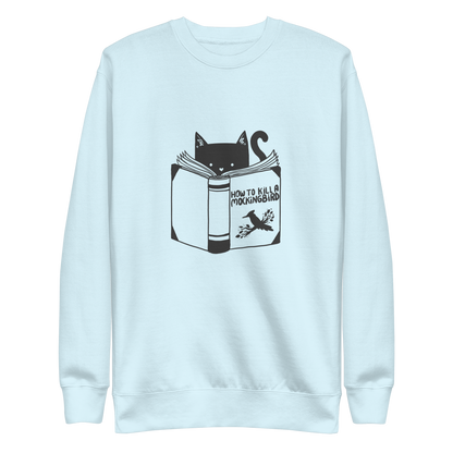 A black and white illustration features a cat peeking over an open book titled 'How to Kill a Mockingbird,' playfully altering the classic novel's title. The cat has a heart-shaped nose and simple, cute facial features. The design is whimsical and ironic, combining classic literature with a humorous twist.