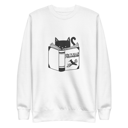 A black and white illustration features a cat peeking over an open book titled 'How to Kill a Mockingbird,' playfully altering the classic novel's title. The cat has a heart-shaped nose and simple, cute facial features. The design is whimsical and ironic, combining classic literature with a humorous twist.