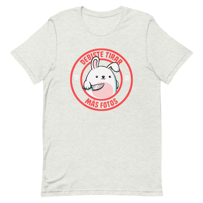 A cute white cartoon bunny with a pink belly stands holding a large kitchen knife in one paw. Surrounding the bunny is a red circular border with the words 'DEBISTE TIRAR MÁS FOTOS'. Small skull icons are on either side of the circle. The overall tone is a mix of adorable and ironic humor.