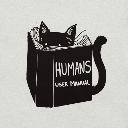 A kitten peeking out from behind a huge book titled "Humans: User Manual". This design plays on the idea that cats are trying to figure out how to control us. Perfect for cat lovers, book fans, and anyone who enjoys lighthearted humor in prints.