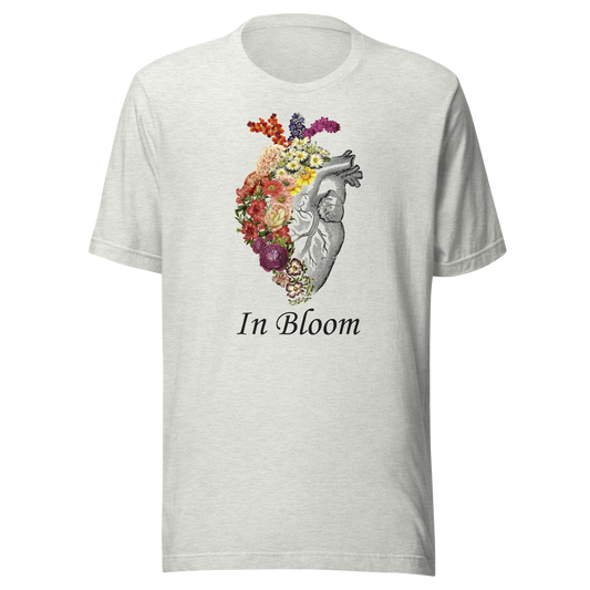 A minimalist anatomical heart partially covered with blooming flowers, paired with the phrase "In Bloom". A poetic design that symbolises growth, transformation, and the beauty of flourishing through change.