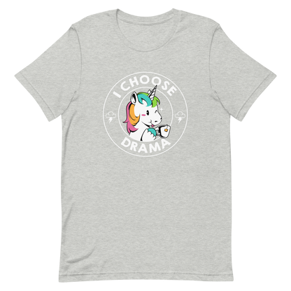 A cartoon unicorn with rainbow-colored mane holds a cup of tea and a heart, encircled by the words 'I Choose Drama'. Two small clouds with lightning bolts flank the unicorn, adding a playful yet slightly edgy vibe. The design is bold and whimsical with a pop-art influence.