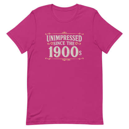 Vintage-style graphic with the phrase “Unimpressed Since the 1900s” in bold distressed lettering, decorated with ornate flourishes and a retro color palette.