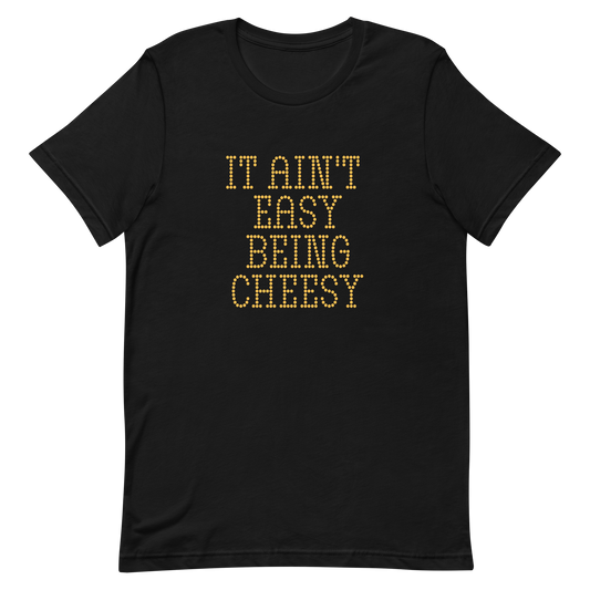 Bold dotted typography spells out ‘It Ain’t Easy Being Cheesy’ in a playful retro style on a yellow background. This funny design mixes wordplay with foodie humor, perfect for pun lovers, cheese fans, retro humor enthusiasts, and anyone who embraces the cringe with pride. A great quirky gift for cheese lovers and humor fans alike.