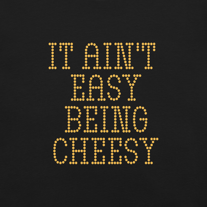 Bold dotted typography spells out ‘It Ain’t Easy Being Cheesy’ in a playful retro style on a yellow background. This funny design mixes wordplay with foodie humor, perfect for pun lovers, cheese fans, retro humor enthusiasts, and anyone who embraces the cringe with pride. A great quirky gift for cheese lovers and humor fans alike.