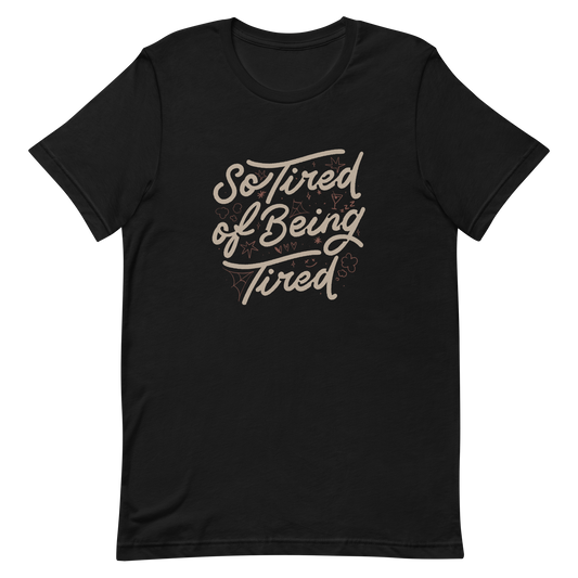 The artwork features the retro-style lettering "So Tired of Being Tired" surrounded by small icons like stars, hearts, clouds, and spider webs. This composition expresses the feeling of constant fatigue in a fun and stylish way. Ideal for those who bring humor to life and those who experience exhaustion in a lighthearted and humorous way.