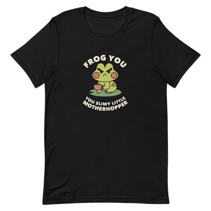 The design features a cartoonish green frog with exaggerated angry features, holding a teacup. The frog has round red cheeks. Above it, text says 'Frog You' and below, 'You Slimy Little Motherhopper'. The style is playful and humorous, reminiscent of cute comic art.