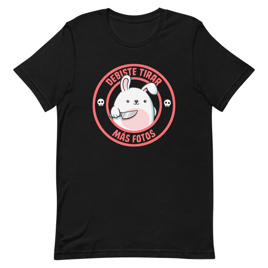 A cute white cartoon bunny with a pink belly stands holding a large kitchen knife in one paw. Surrounding the bunny is a red circular border with the words 'DEBISTE TIRAR MÁS FOTOS'. Small skull icons are on either side of the circle. The overall tone is a mix of adorable and ironic humor.