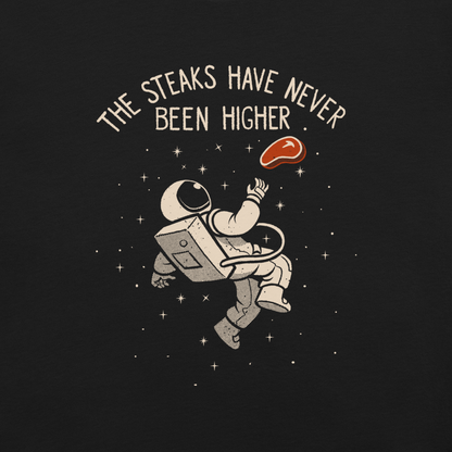An astronaut floating through space with a small steak in front of him, paired with the phrase ‘The Steaks Have Never Been Higher’. A playful and humorous design that blends space exploration with a clever visual pun. Perfect for fans of witty wordplay and quirky art.