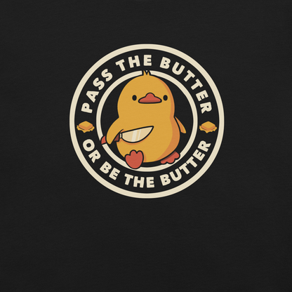 A yellow duckling holding a butter knife in a cute pose, around him the phrase "Pass the butter or be the butter". An art with a lot of humor for those who love ducks.