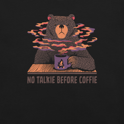 A large brown bear holding a purple coffee cup with a campfire design, with steam rising as if the coffee were piping hot. Below it appears the phrase ‘No Talkie Before Coffie’. A fun design for coffee lovers and anyone who isn’t ready to talk before their first cup.