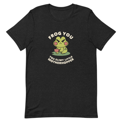 The design features a cartoonish green frog with exaggerated angry features, holding a teacup. The frog has round red cheeks. Above it, text says 'Frog You' and below, 'You Slimy Little Motherhopper'. The style is playful and humorous, reminiscent of cute comic art.